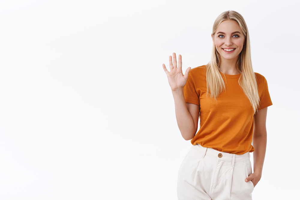 friendly-carefree-sassy-attractive-blond-woman-orange-t-shirt-pants-raise-palm-waving-hand-greeting-gesture-smiling-joyfully-say-hi-hello-welcome-you-guest-white-background_4